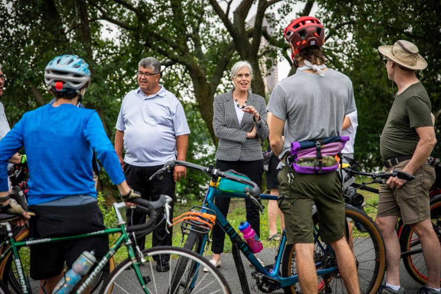 Rep. Clark talks with Medford residents who are riding bikes along a greenway.
