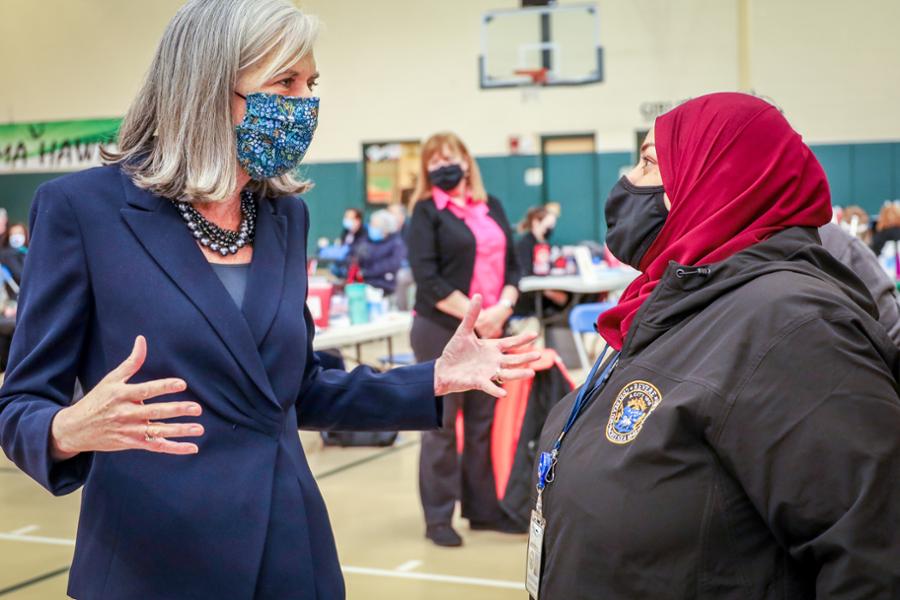 Rep. Clark speaks with a health care provider, who is wearing a hijab, at a vaccine drive in Revere.