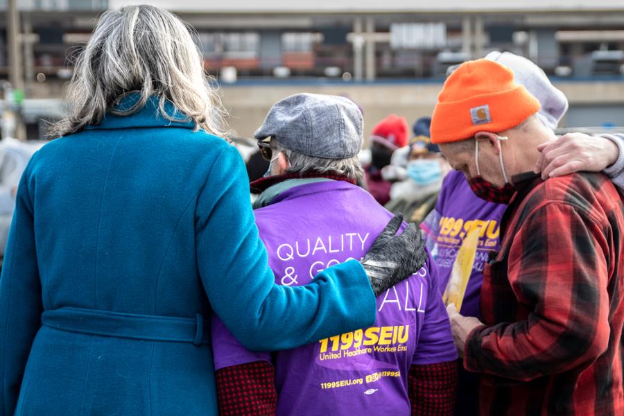 Rep. Clark places her arm around a member of the local SEIU union at a rally.