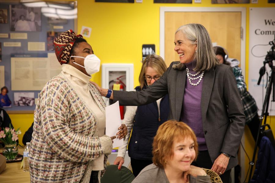 Rep. Clark laughs with a Black woman as a Martin Luther King Day event in Medford.