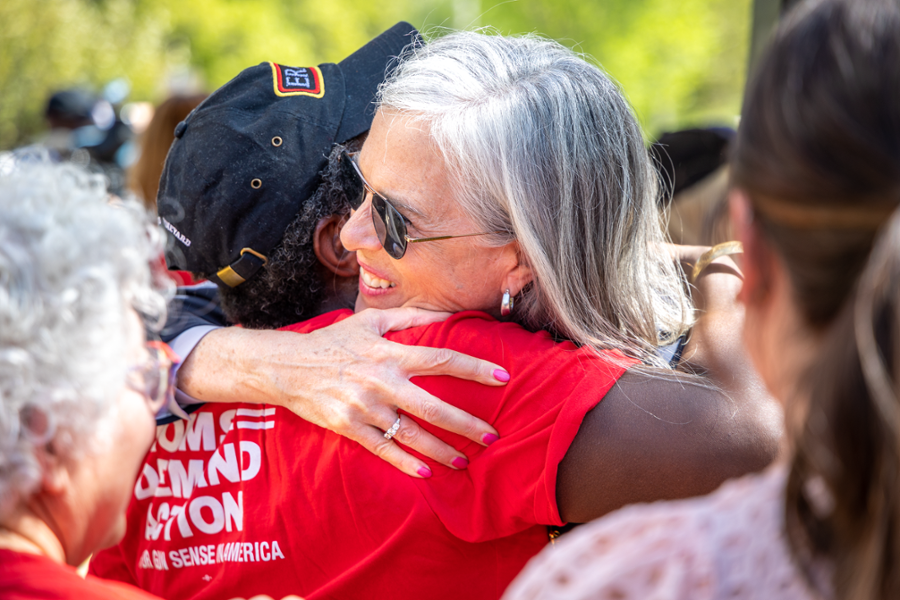 Rep. Clark hugs former Framingham Mayor Yvonne Spicer outside of a school during a rally to improve gun safety laws.
