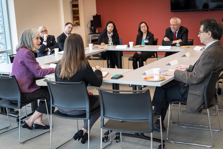 Rep. Clark sits at a conference room table with staff from South Cove Medical Center in Malden.