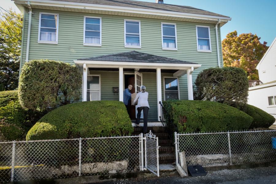 Rep. Clark is handing food to a senior citizen in Waltham after bringing it to his house while volunteering for Meals on Wheels.
